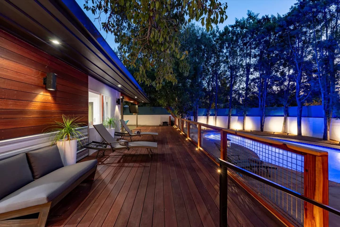 Luxury Los Angeles vacation rental with modern deck and pool at dusk, managed by LA Luxury BnB